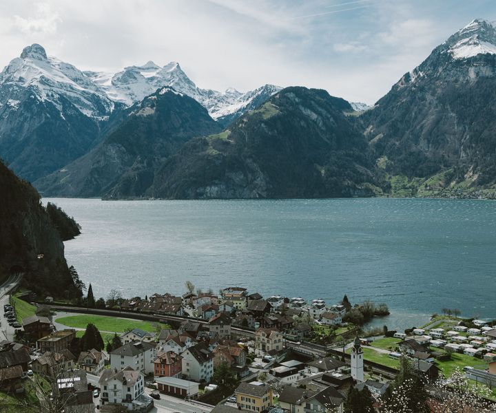 Alpine lake surrounded by snow-capped mountains above a small European town